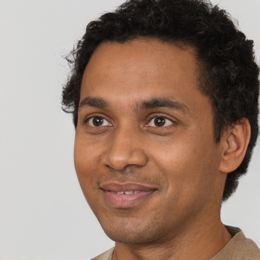 Joyful black young-adult male with short  brown hair and brown eyes