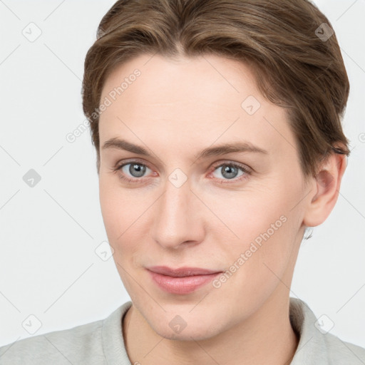 Joyful white young-adult female with short  brown hair and grey eyes