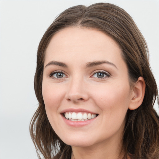 Joyful white young-adult female with long  brown hair and grey eyes