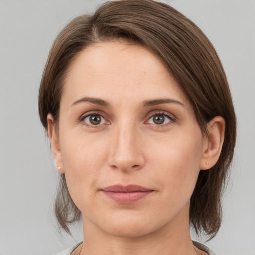 Joyful white young-adult female with medium  brown hair and grey eyes