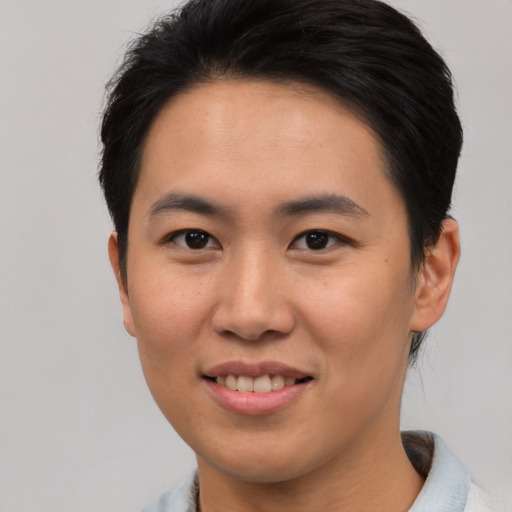 Joyful asian young-adult male with short  brown hair and brown eyes