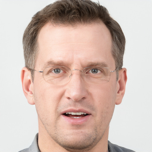 Joyful white adult male with short  brown hair and grey eyes