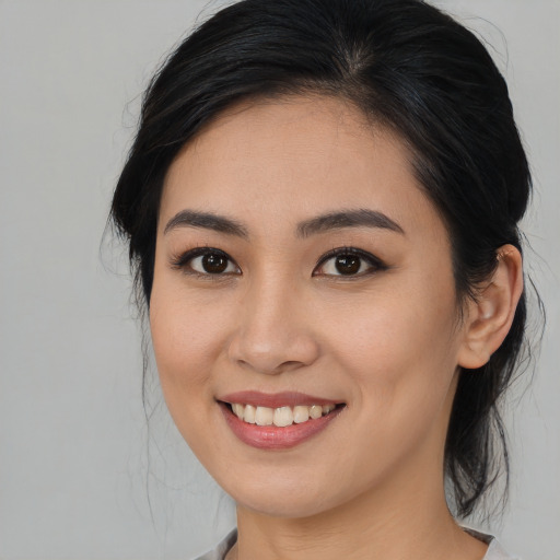 Joyful asian young-adult female with medium  brown hair and brown eyes
