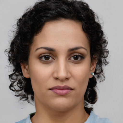Joyful latino young-adult female with medium  brown hair and brown eyes
