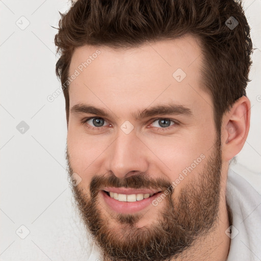 Joyful white young-adult male with short  brown hair and brown eyes