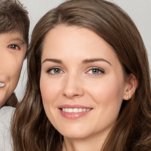 Joyful white young-adult female with long  brown hair and brown eyes