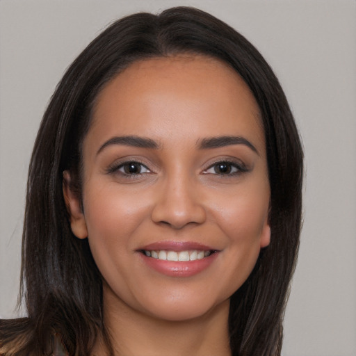 Joyful latino young-adult female with long  brown hair and brown eyes