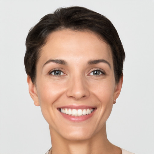 Joyful white young-adult female with short  brown hair and grey eyes