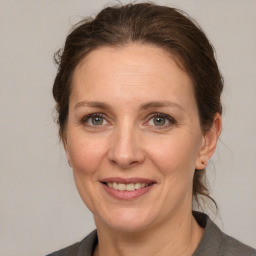 Joyful white adult female with medium  brown hair and grey eyes