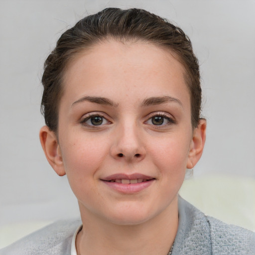 Joyful white young-adult female with short  brown hair and blue eyes