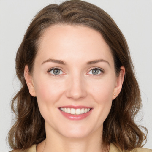 Joyful white young-adult female with medium  brown hair and grey eyes