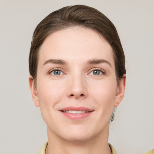 Joyful white young-adult female with short  brown hair and grey eyes