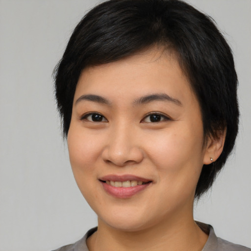 Joyful asian young-adult female with medium  black hair and brown eyes