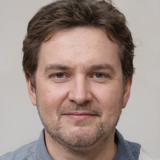 Joyful white adult male with short  brown hair and grey eyes