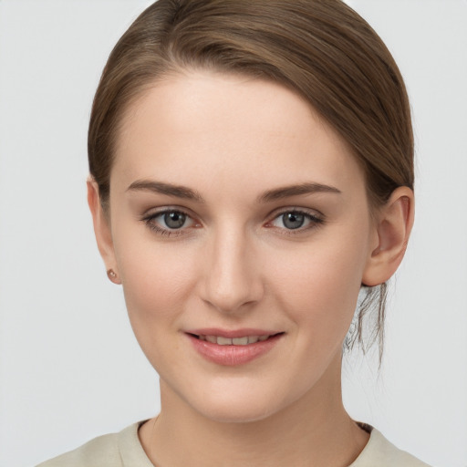 Joyful white young-adult female with medium  brown hair and grey eyes