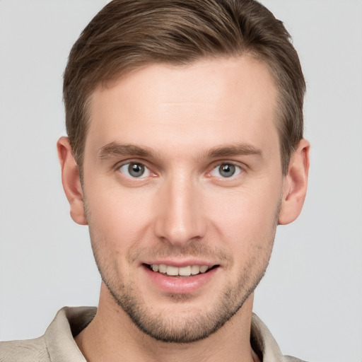 Joyful white young-adult male with short  brown hair and grey eyes