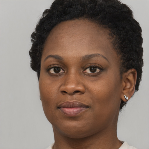 Joyful black young-adult female with short  brown hair and brown eyes