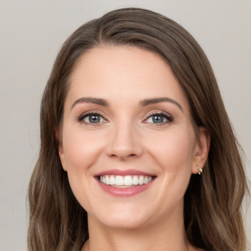 Joyful white young-adult female with long  brown hair and grey eyes