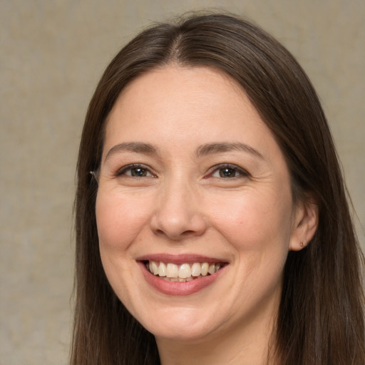 Joyful white young-adult female with long  brown hair and brown eyes