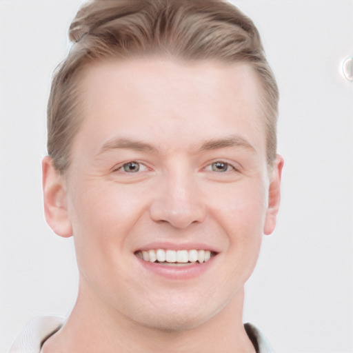 Joyful white young-adult male with short  brown hair and blue eyes