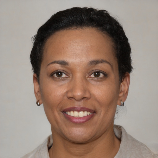 Joyful black adult female with short  black hair and brown eyes