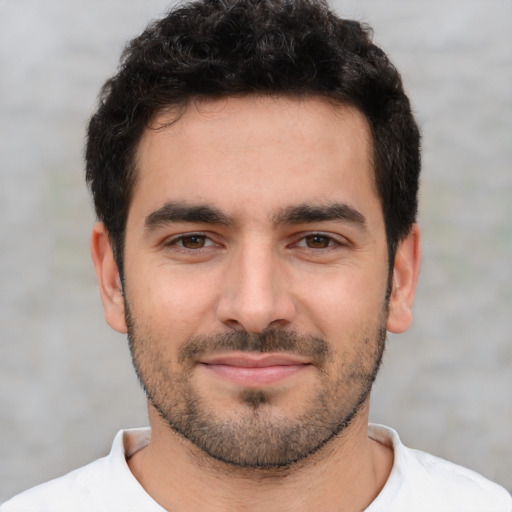 Joyful white young-adult male with short  black hair and brown eyes