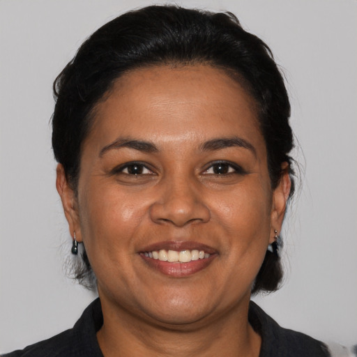 Joyful latino adult female with medium  black hair and brown eyes