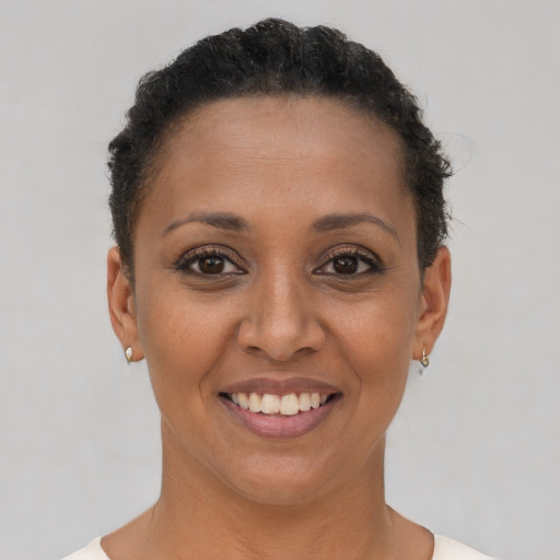 Joyful black adult female with short  brown hair and brown eyes