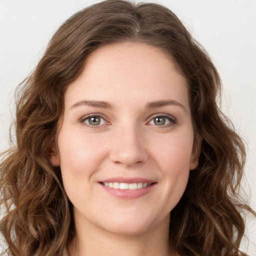 Joyful white young-adult female with long  brown hair and green eyes