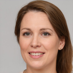 Joyful white young-adult female with long  brown hair and green eyes