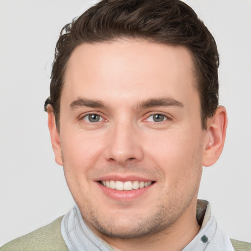 Joyful white young-adult male with short  brown hair and grey eyes