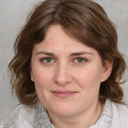 Joyful white young-adult female with medium  brown hair and blue eyes