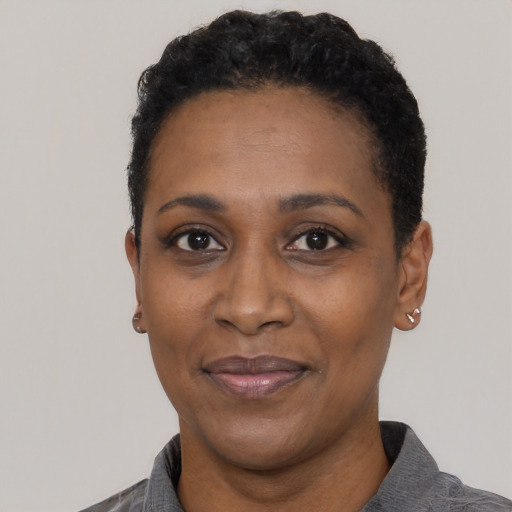 Joyful black adult female with short  black hair and brown eyes