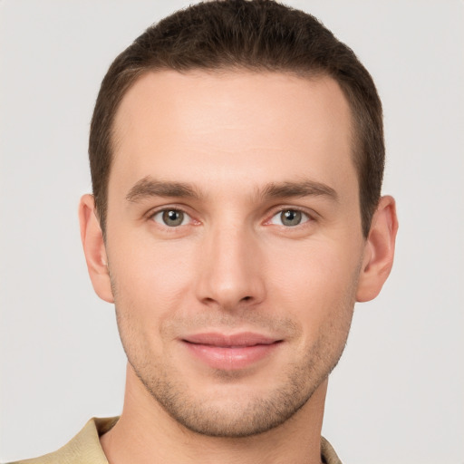 Joyful white young-adult male with short  brown hair and grey eyes