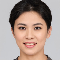 Joyful asian young-adult female with short  brown hair and brown eyes