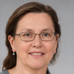 Joyful white adult female with medium  brown hair and blue eyes