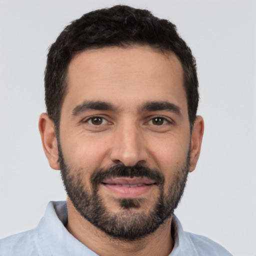 Joyful white young-adult male with short  black hair and brown eyes