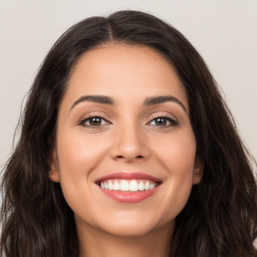 Joyful white young-adult female with long  brown hair and brown eyes