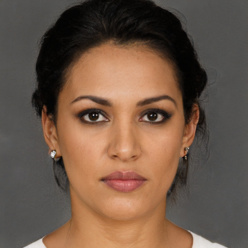 Joyful latino young-adult female with medium  brown hair and brown eyes