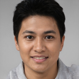 Joyful asian young-adult male with short  black hair and brown eyes