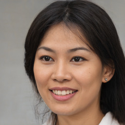 Joyful asian young-adult female with long  brown hair and brown eyes