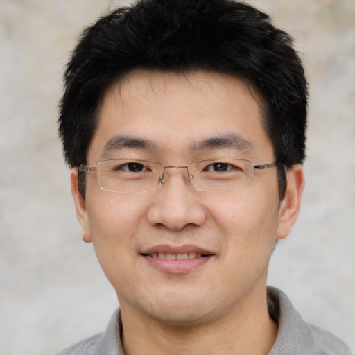 Joyful asian young-adult male with short  black hair and brown eyes