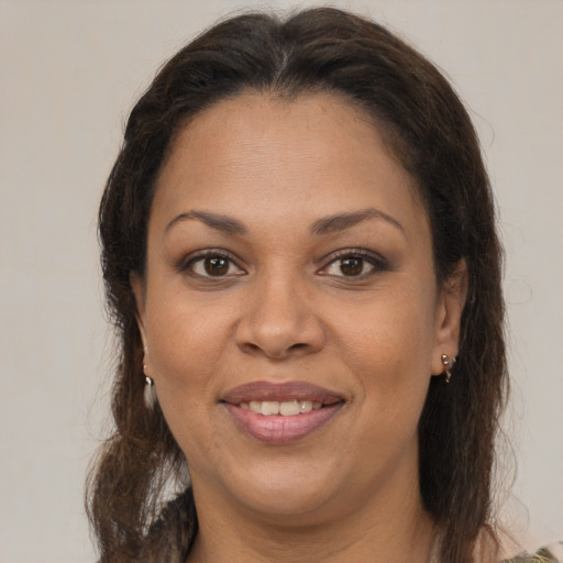 Joyful latino adult female with medium  brown hair and brown eyes