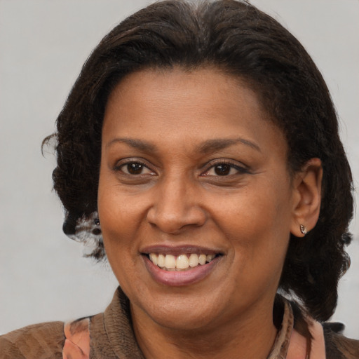 Joyful black adult female with medium  brown hair and brown eyes