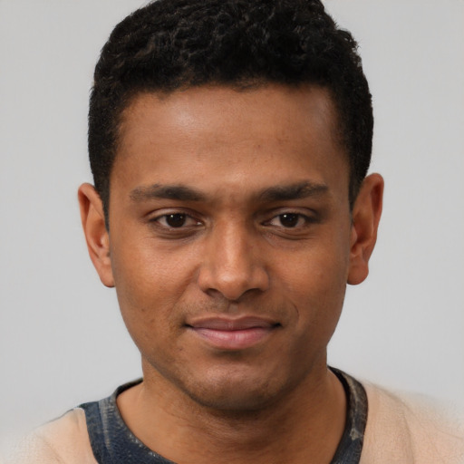 Joyful black young-adult male with short  brown hair and brown eyes