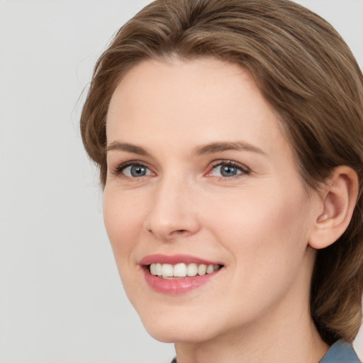 Joyful white young-adult female with medium  brown hair and grey eyes