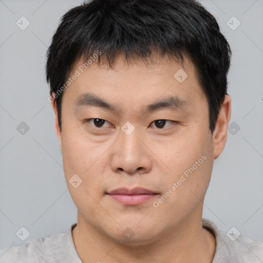 Joyful asian young-adult male with short  brown hair and brown eyes