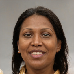 Joyful latino adult female with medium  brown hair and brown eyes