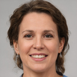 Joyful white adult female with medium  brown hair and grey eyes