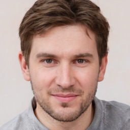 Joyful white young-adult male with short  brown hair and grey eyes